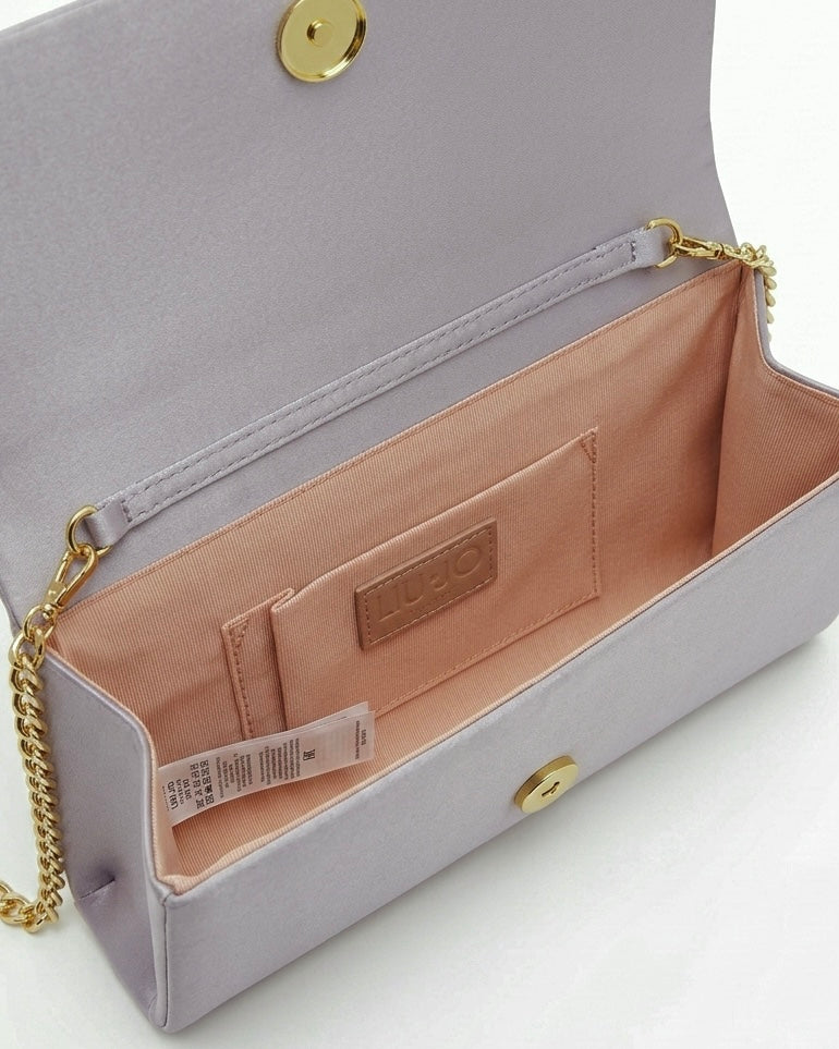Borsa clutch Liu Jo in raso grigio argento con maxi fiocco frontale, logo in strass e tracolla a catena oro-interno.