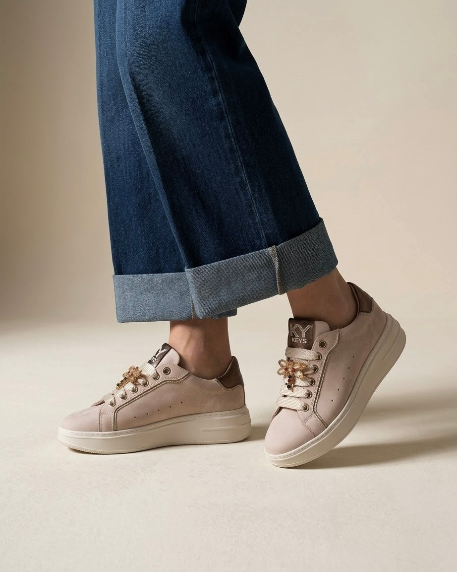 Sneakers platform Keys donna color cipria con dettagli bronzo e farfalla gioiello sui lacci - indossate con jeans.