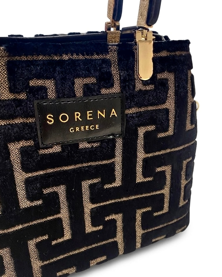 Borsa a mano Sorena prodotta in Grecia in tessuto jacquard vellutato con motivo geometrico greco nero e beige, manici neri e tracolla a catena dorata - Buttò Calzature - logo.