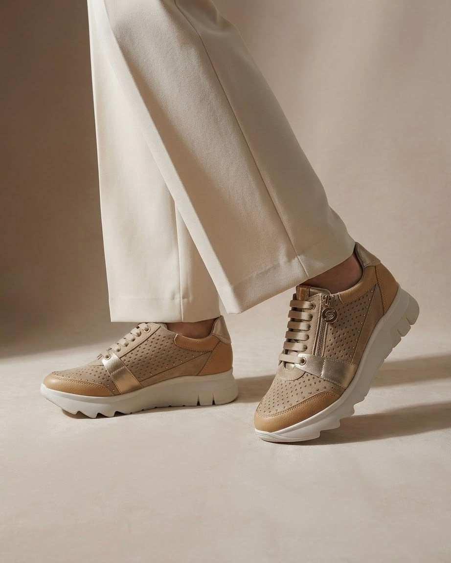 Sneakers Stonefly da donna color sabbia con pelle traforata, dettagli laminati oro, suola bianca sagomata e pratica zip laterale - indossate.