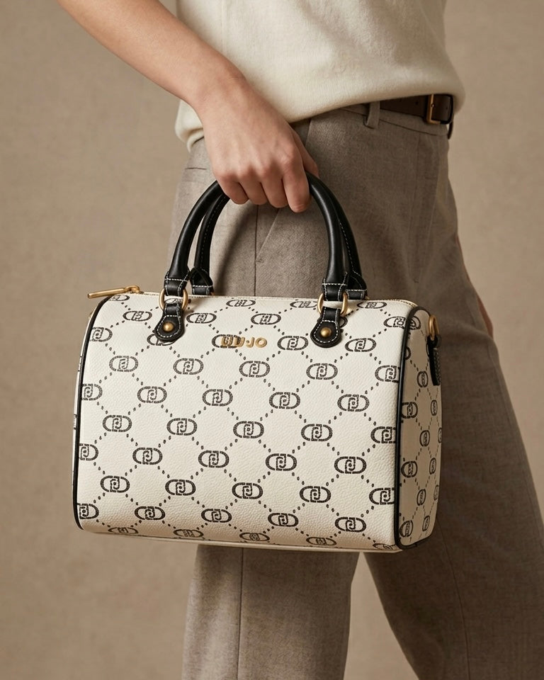 Borsa a bauletto Liu Jo Monogram bianco e nero con doppi manici e logo dorato, vista frontale su sfondo bianco-indossata.