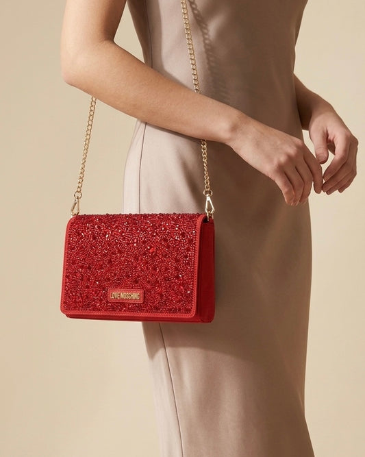 Borsa donna Love Moschino rossa elegante con copertura di strass, logo metallico dorato e tracolla a catena gold-modella.