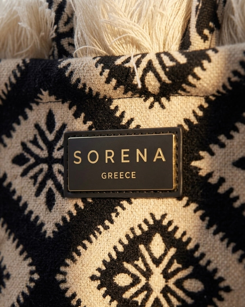Borsa a mano Sorena prodotta in Grecia in tessuto jacquard geometrico nero e beige con frange dorate e manici in tinta - Buttò Calzature - logo.