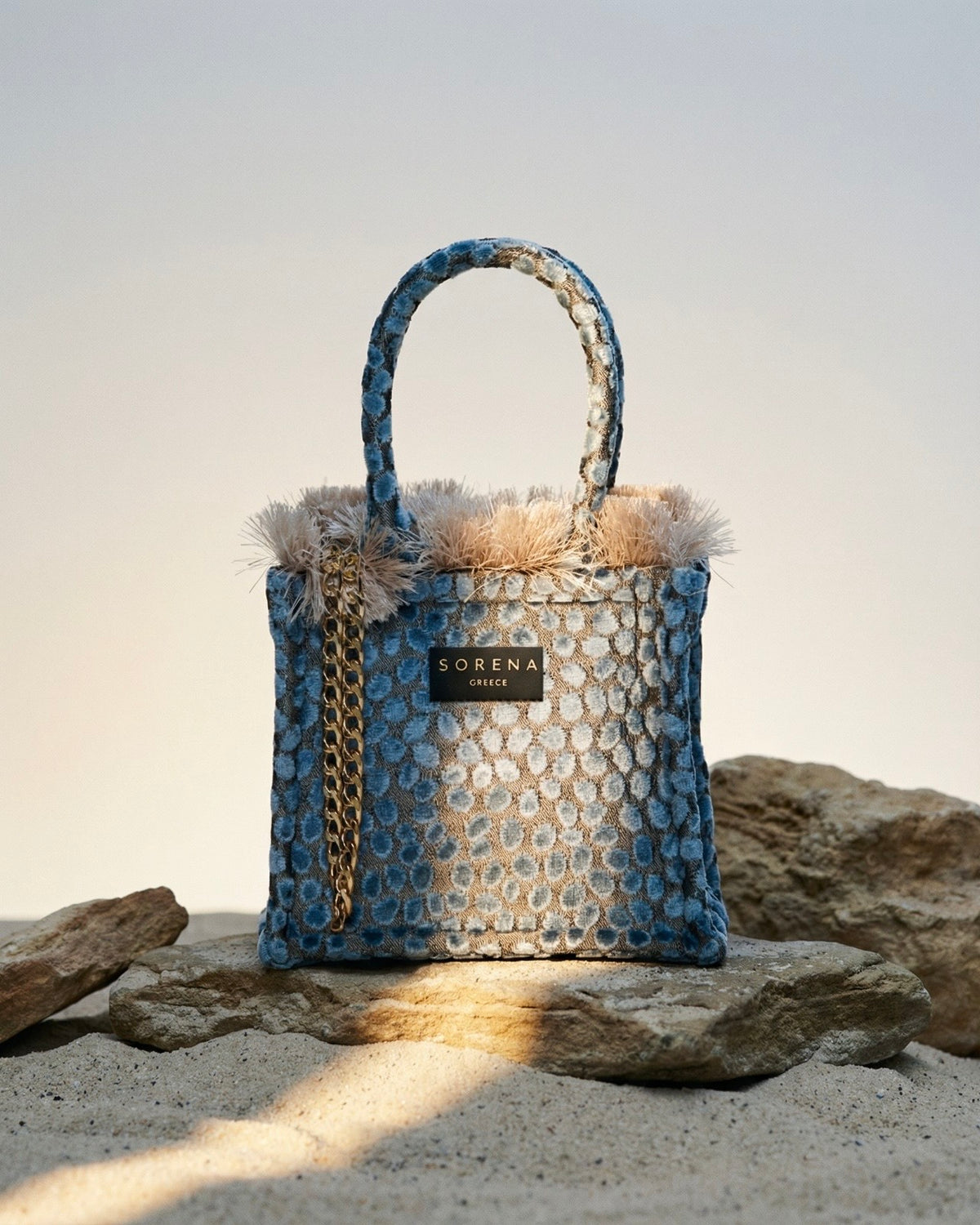 Borsa a mano Sorena prodotta in Grecia in tessuto jacquard vellutato azzurro avio a pois con frange beige e manici in tinta - Buttò Calzature.
