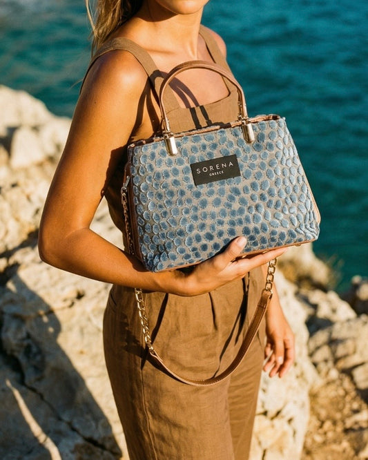 Borsa a mano Sorena prodotta in Grecia in tessuto jacquard vellutato azzurro avio a pois con manici nude cammello, etichetta nera e catena dorata - Buttò Calzature - modella.