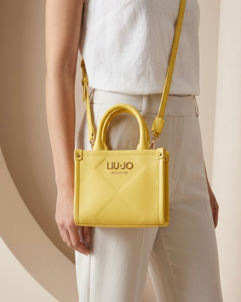 Mini borsa a mano e a tracolla Liu Jo gialla con doppi manici, chiusura a zip e logo dorato - Buttò Calzature - modella.