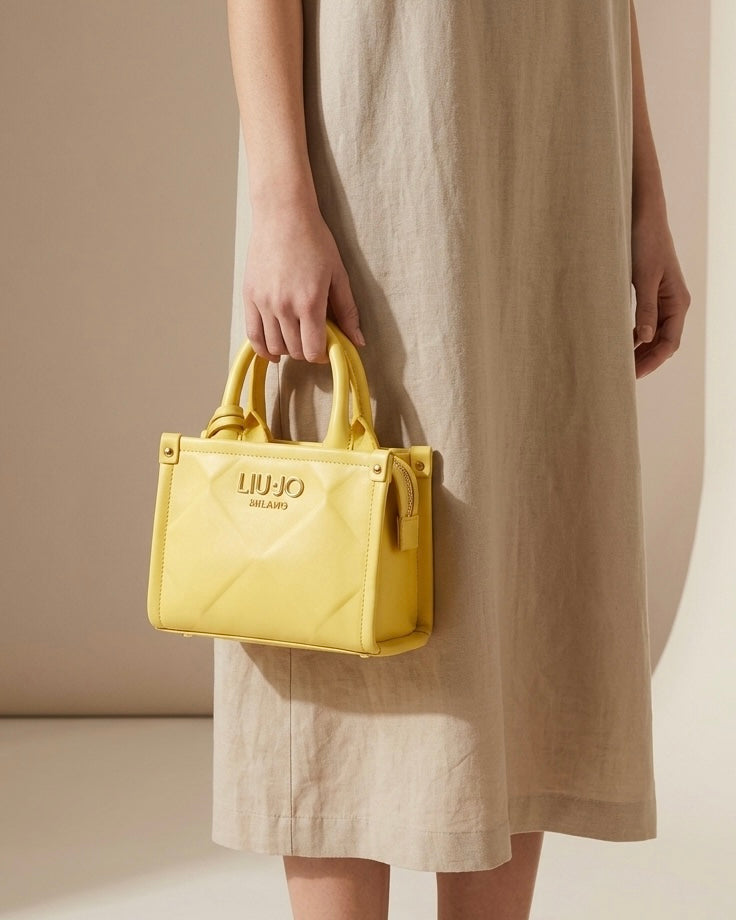 Mini borsa a mano e a tracolla Liu Jo gialla con doppi manici, chiusura a zip e logo dorato - Buttò Calzature - modella.