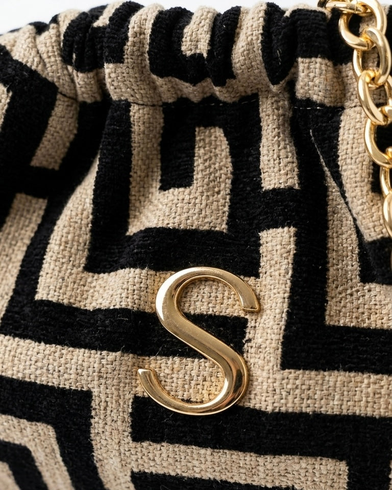 Borsa pochette clutch Sorena prodotta in Grecia in tessuto jacquard con motivo geometrico greco nero e beige, logo S e catena dorati - Buttò Calzature - logo.