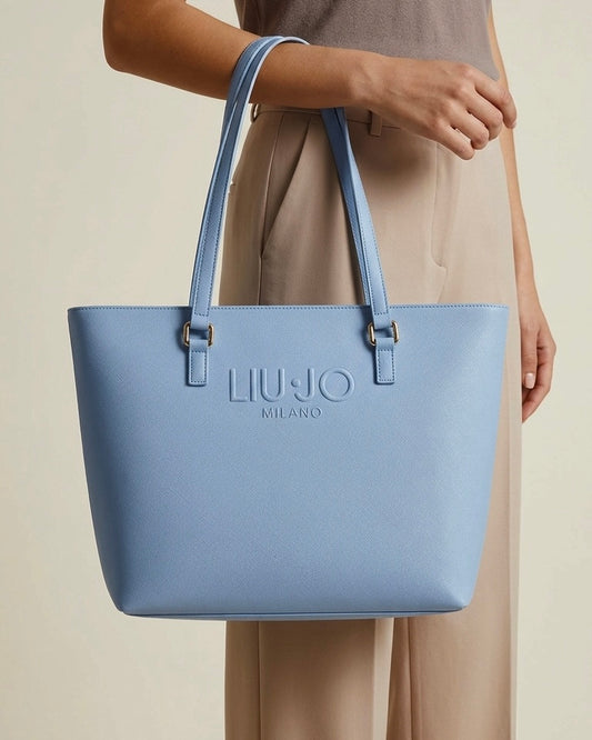 Borsa a spalla Liu Jo color azzurro polvere in trama saffiano con logo "Liu Jo Milano" a rilievo e doppi manici lunghi-modella.