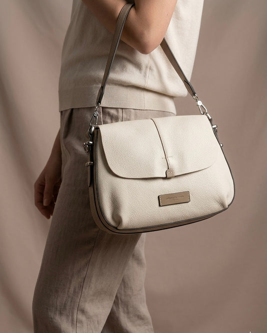 Elegante borsa a spalla da donna Pelletteria Veneta in vera pelle grana dollaro, disponibile nei colori cammello e panna, con manico singolo e hardware argento. Made in Italy-modella.