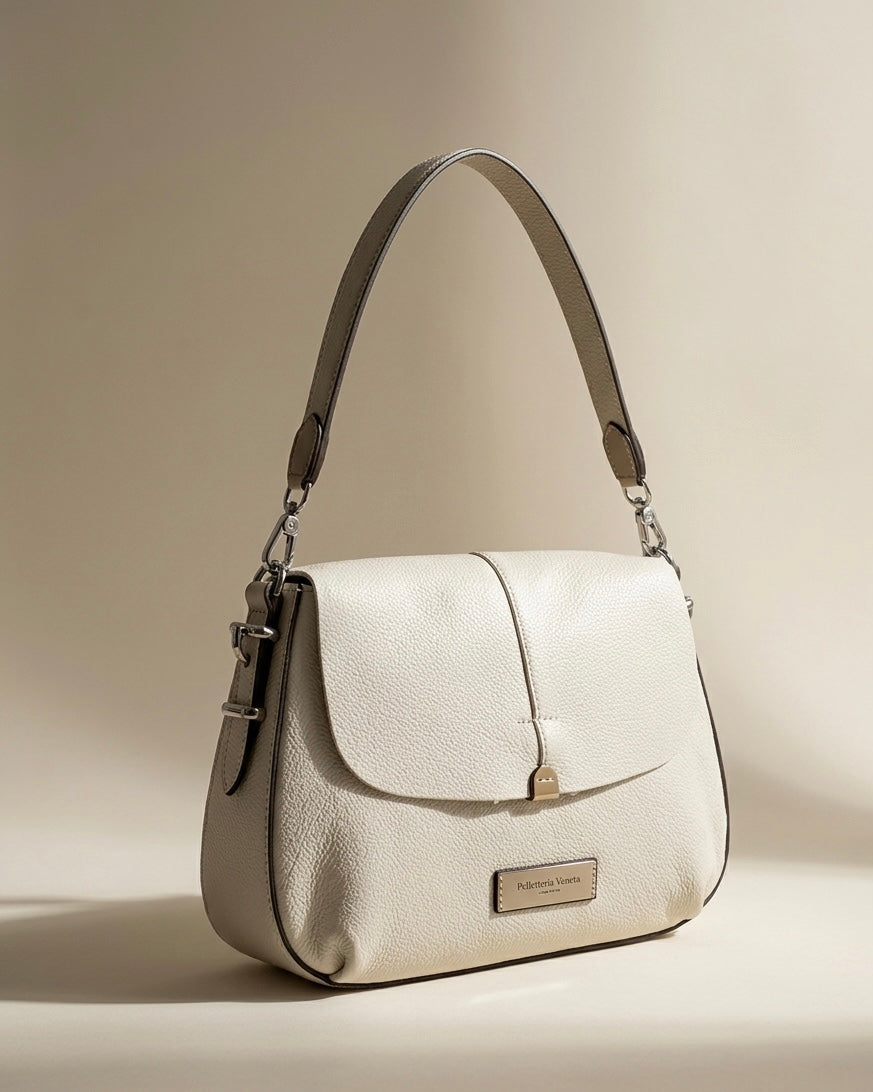 Elegante borsa a spalla da donna Pelletteria Veneta in vera pelle grana dollaro, disponibile nei colori cammello e panna, con manico singolo e hardware argento. Made in Italy.