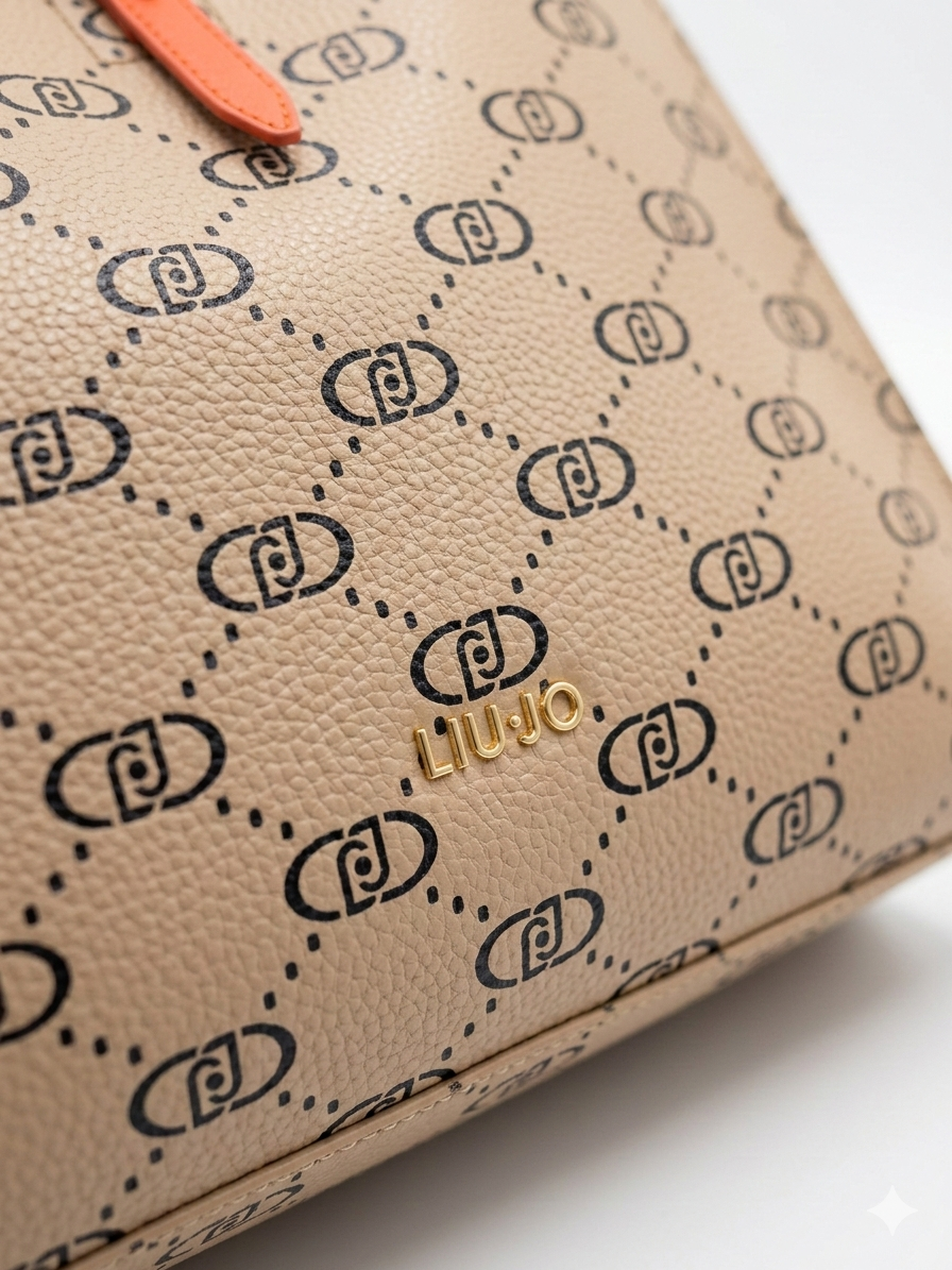 Dettaglio logo metallico dorato su borsa Liu Jo monogram beige con finiture arancio.