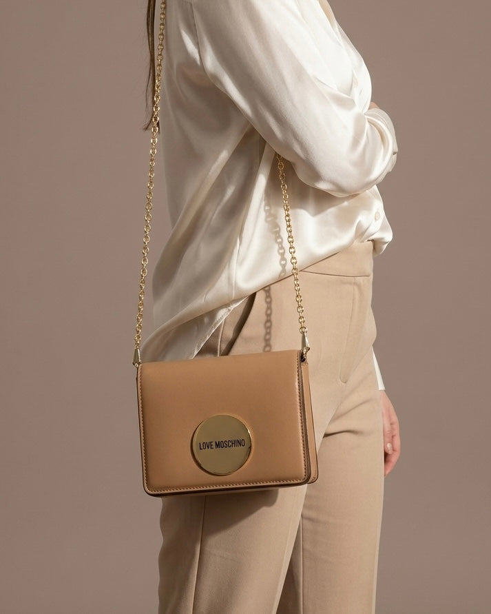 Borsa a tracolla Love Moschino color cuoio con catena dorata e logo circolare gold frontale-modella.