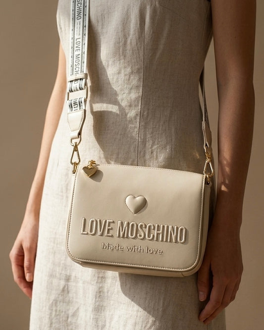 Borsa a spalla Love Moschino color panna con logo a rilievo, cuore e ampia tracolla in tessuto bianco e nero logato-modella.