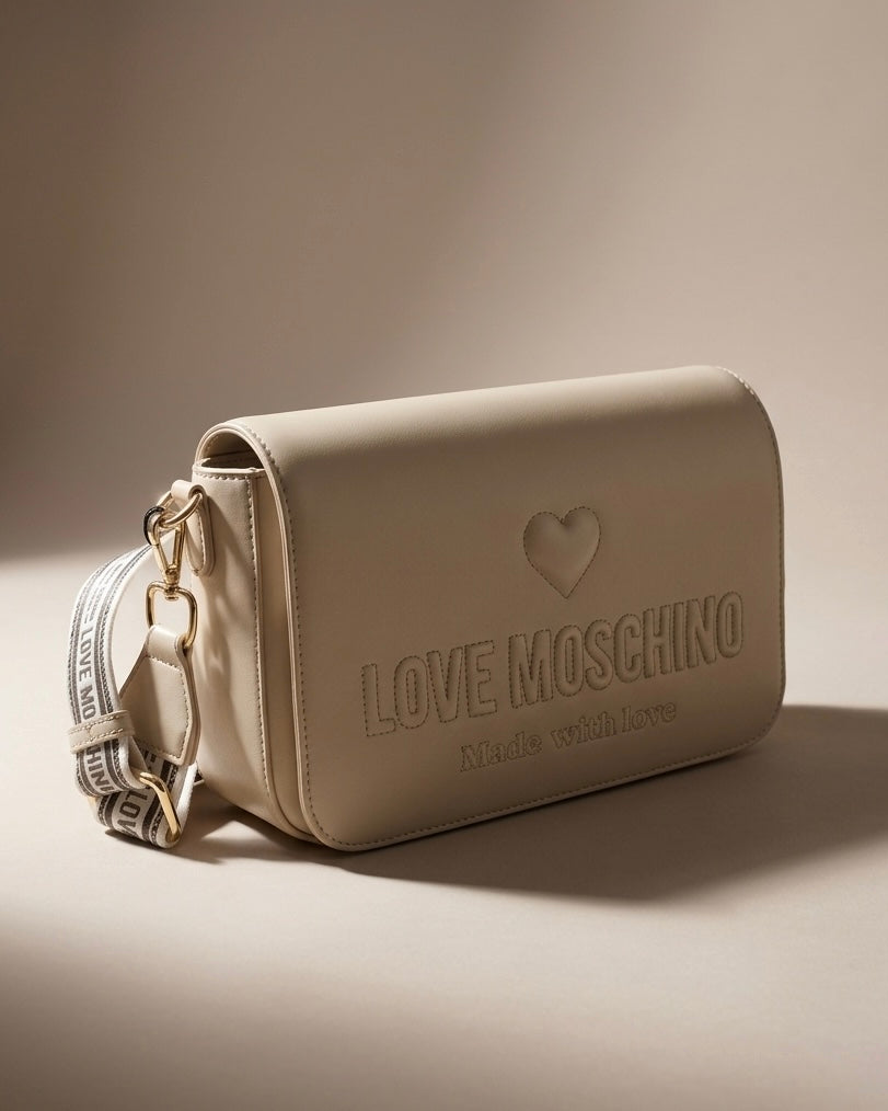 Borsa a spalla Love Moschino color panna con logo a rilievo, cuore e ampia tracolla in tessuto bianco e nero logato.