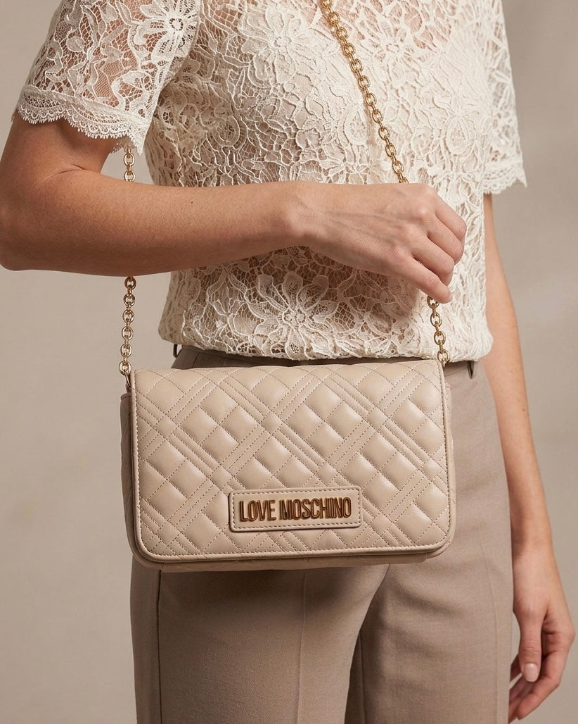 Borse Love Moschino beige nude con trapuntatura geometrica, tracolla a catena e logo dorato-modella.