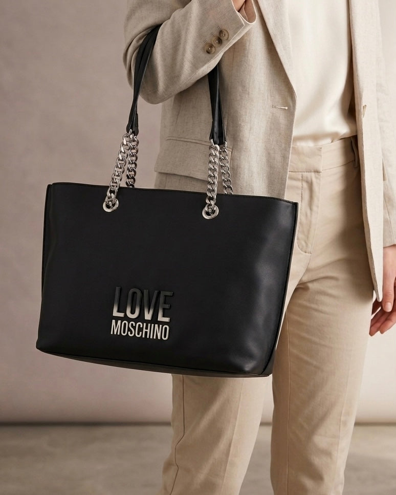Borse Love Moschino shopping bag nere con manici a catena argentata e maxi logo metallico frontale-modella.