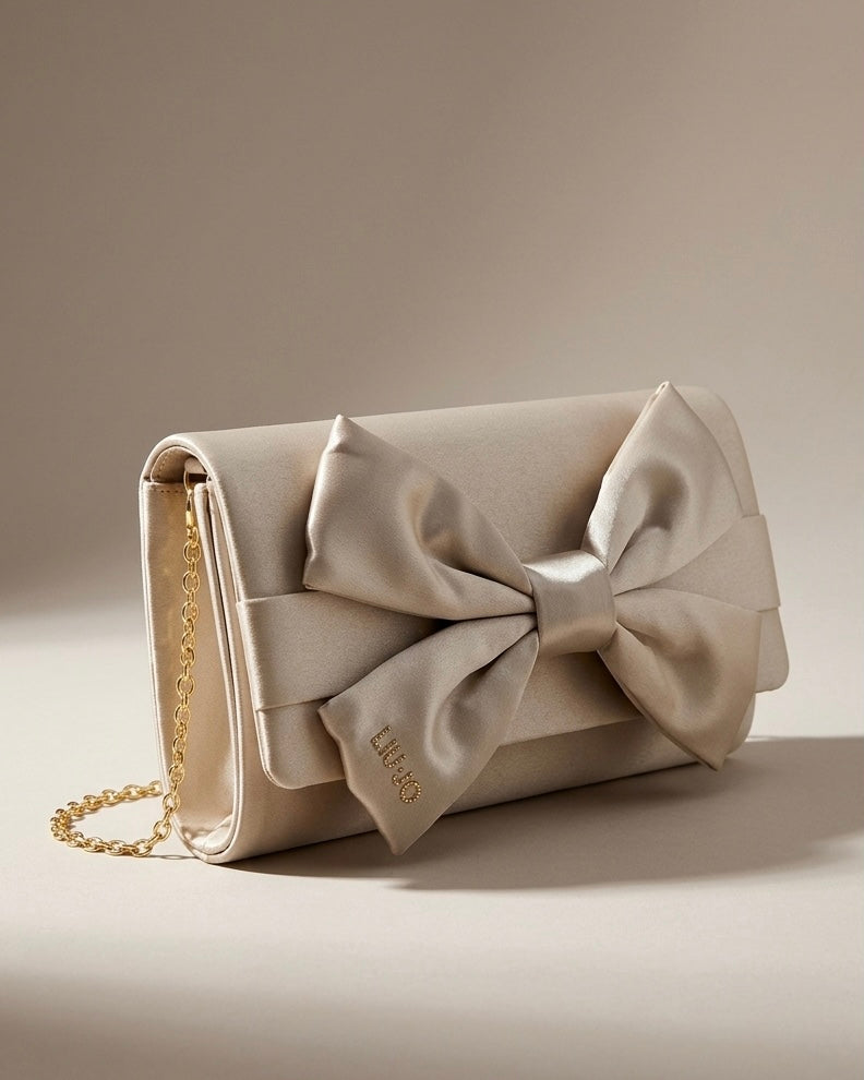 Pochette Liu Jo in satin beige con maxi fiocco frontale e tracolla a catena dorata.