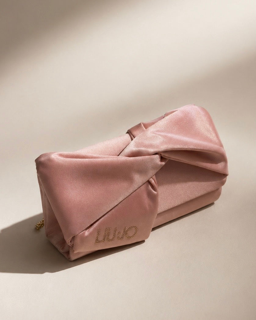 Pochette Liu Jo in satin rosa cipria con nodo centrale e logo in strass e catenina oro.