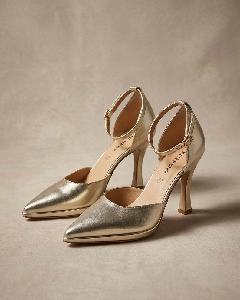 Scarpe décolleté eleganti color oro laminato, punta affusolata, tacco alto a rocchetto e cinturino sottile regolabile alla caviglia.