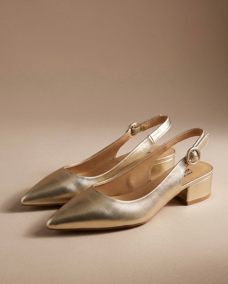 Scarpe eleganti modello slingback in finitura oro laminato, punta affusolata, tacco basso squadrato a blocco e cinturino regolabile con fibbia tonda.