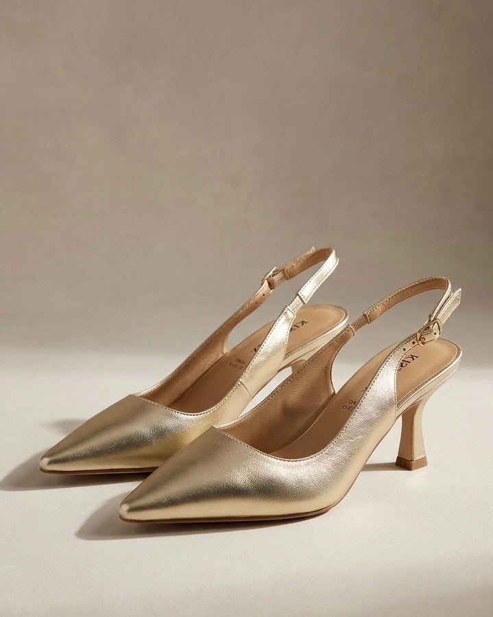 Scarpe eleganti modello slingback in finitura oro laminato, punta affusolata, tacco medio a rocchetto e cinturino regolabile con fibbia dorata.