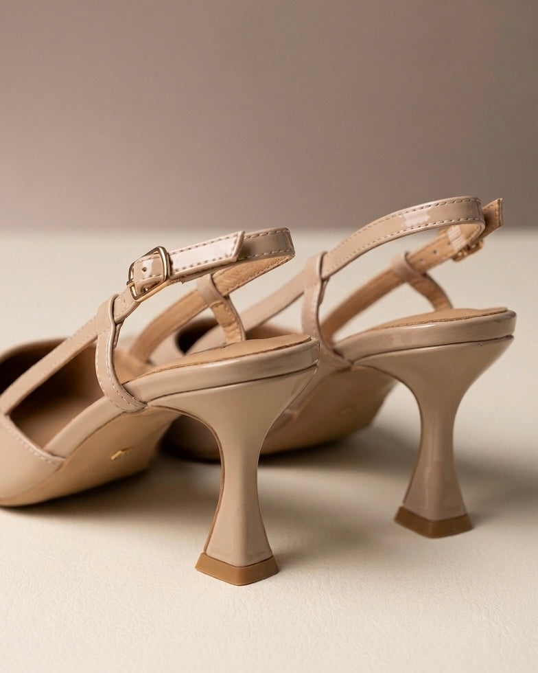 Scarpe eleganti modello slingback in vernice lucida color nude, punta sfilata affusolata, tacco alto sagomato a rocchetto e cinturino sottile regolabile con fibbia-retro.