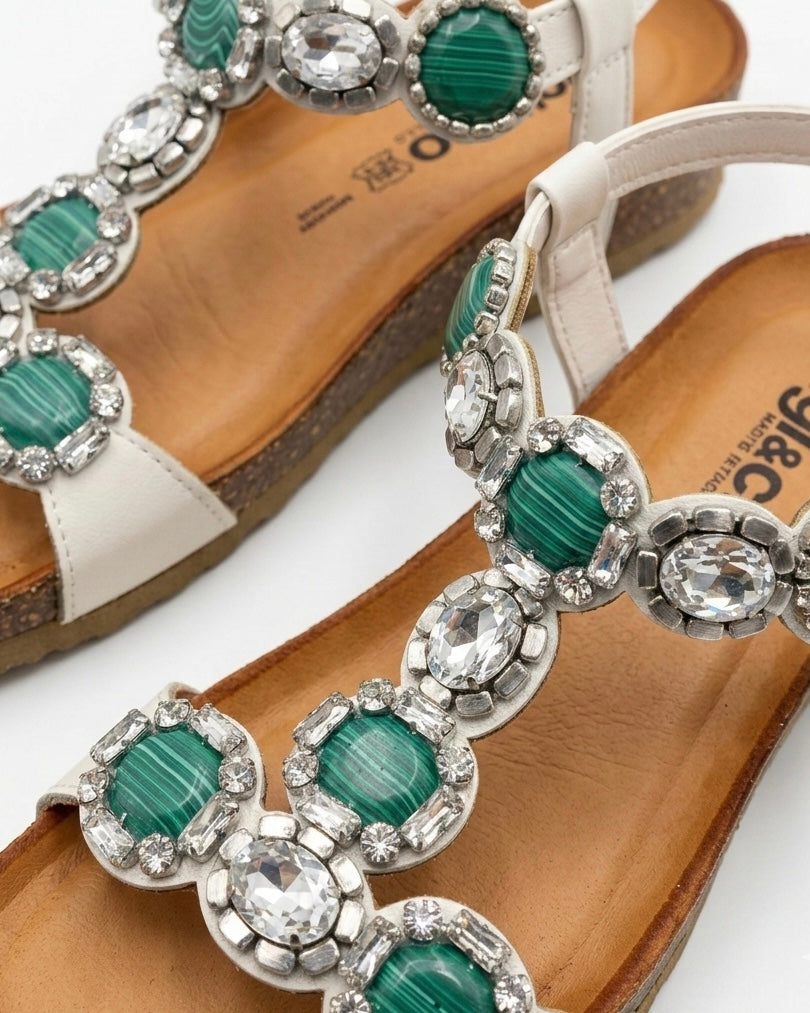 Sandali bassi da donna marca Igi&Co con grandi pietre circolari verdi screziate e cristalli luminosi, cinturino bianco e suola anatomica in sughero-dettaglio.