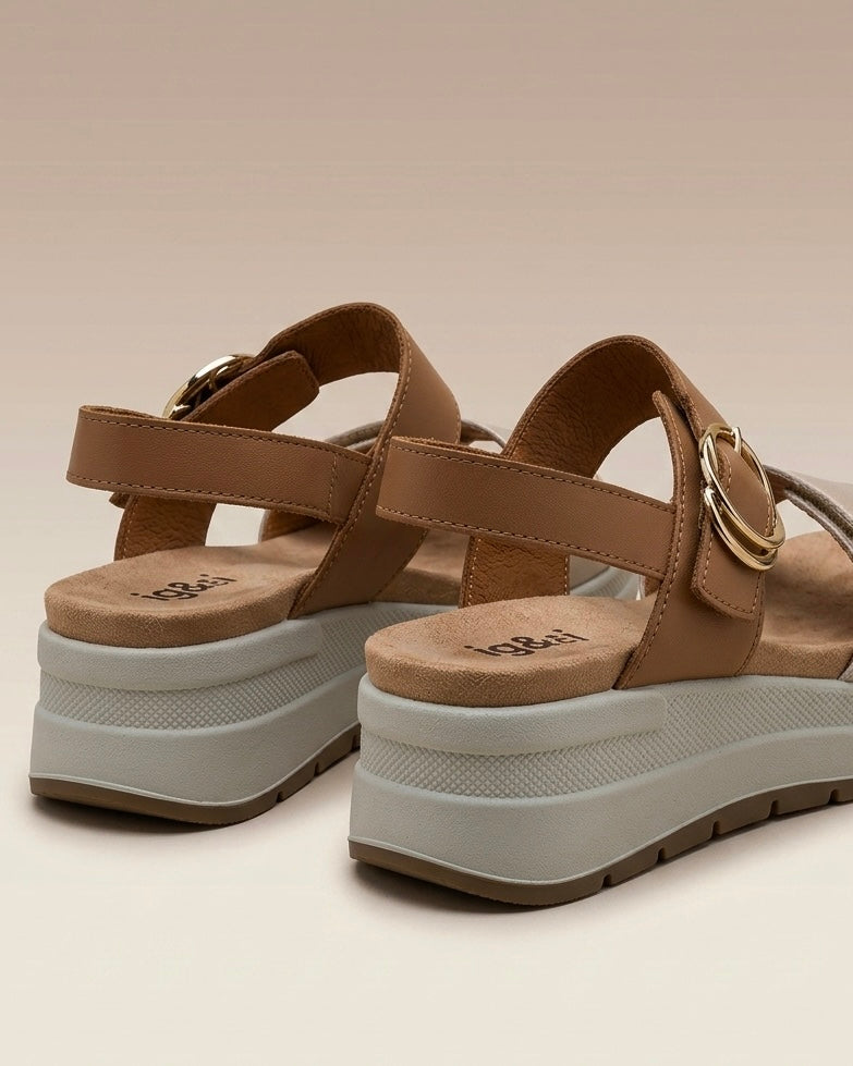 Sandali da donna Igi&Co in vera pelle panna e cuoio, con maxi fibbia tonda dorata, cinturino regolabile e zeppa leggera ammortizzata-retro.