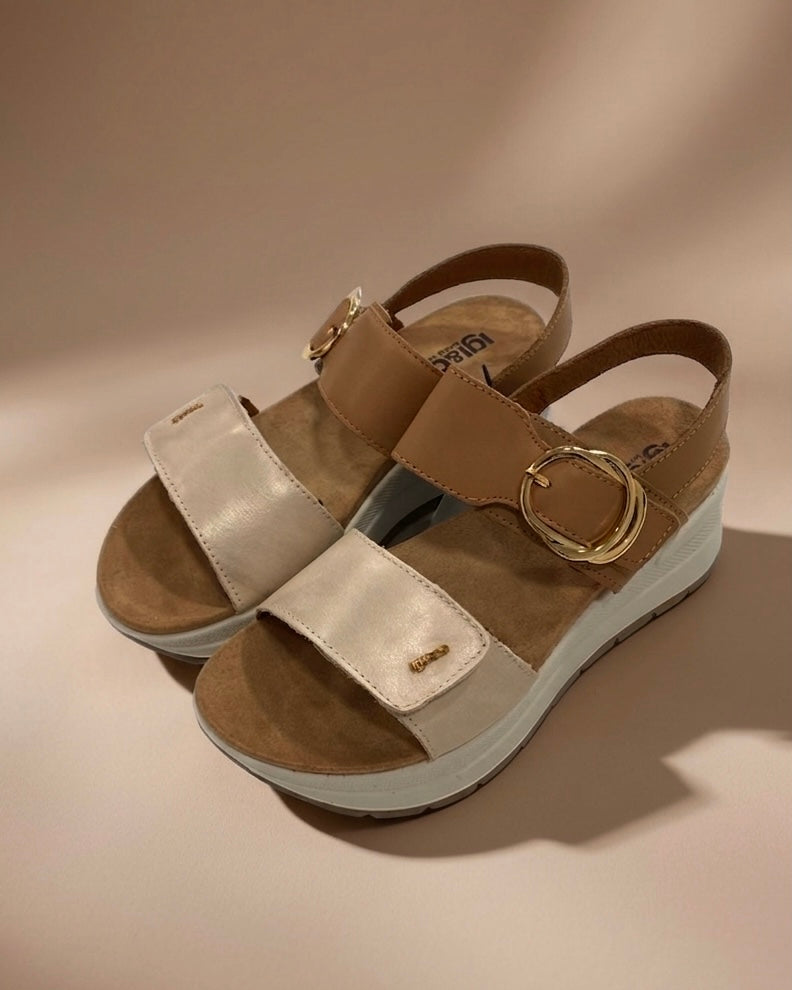 Sandali da donna Igi&Co in vera pelle panna e cuoio, con maxi fibbia tonda dorata, cinturino regolabile e zeppa leggera ammortizzata.