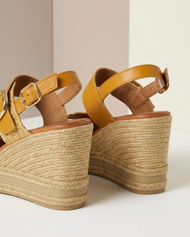 Sandali in vera pelle giallo senape con zeppa alta in corda e fascia anteriore intrecciata-retro.