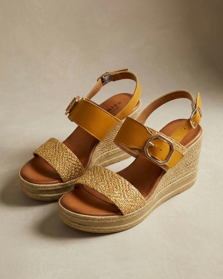 Sandali in vera pelle giallo senape con zeppa alta in corda e fascia anteriore intrecciata.