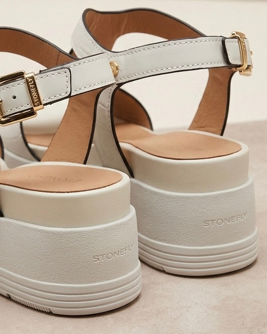 Sandali donna Stonefly in pelle bianca con suola platform alta, fascia centrale sagomata decorata con borchie dorate a piramide e cinturino alla caviglia-retro.