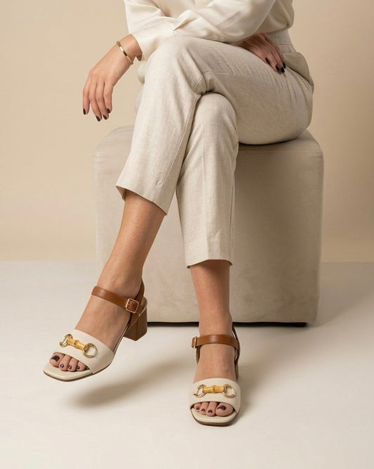 Sandali da donna marca REPO realizzati in vera pelle beige e cuoio, con elegante morsetto dorato e dettaglio effetto bamboo sulla fascia frontale-modella.
