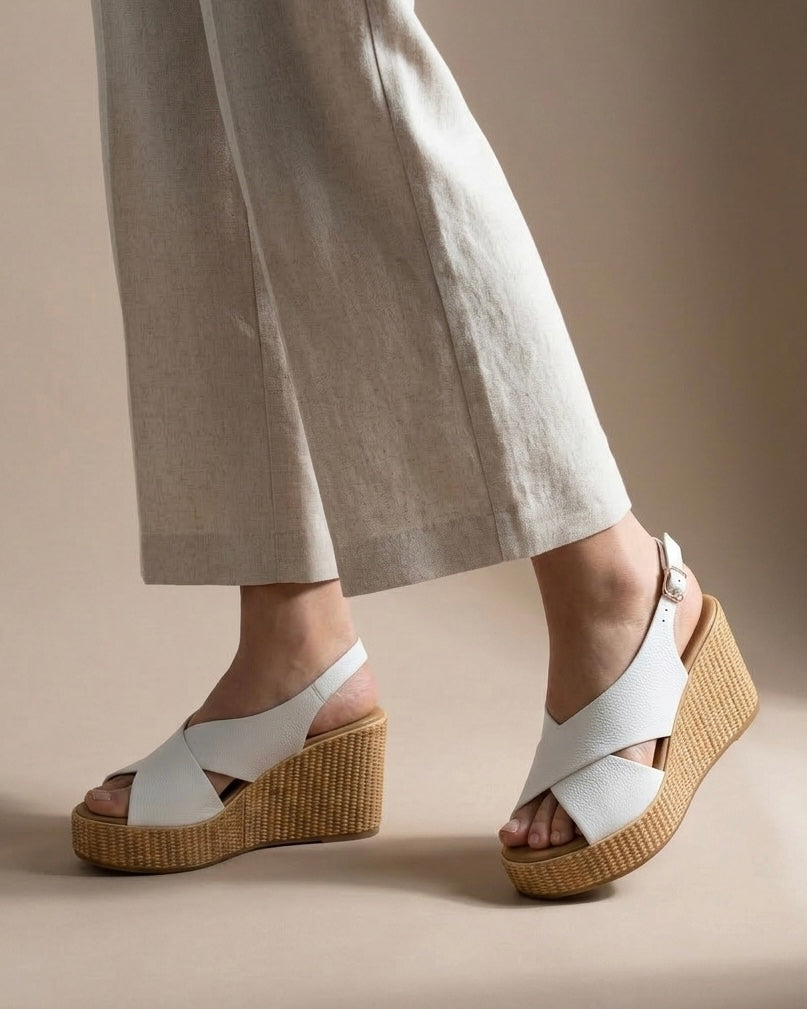 Sandali da donna marca REPO con alta zeppa intrecciata effetto naturale, tomaia in pelle bianca martellata a incrocio e cinturino slingback regolabile-indossati.