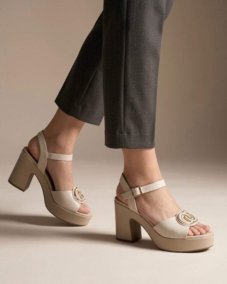 Sandali slingback da donna marca REPO color beige panna, con maxi fibbia logata dorata sulla fascia, cinturino regolabile e tacco largo con platform-indossati.