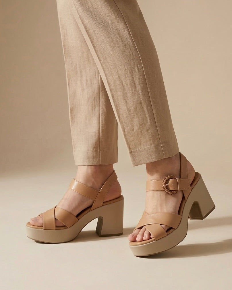 Sandali slingback da donna marca REPO color nude/beige, fascia incrociata anteriore, cinturino con fibbia dorata lavorata e suola platform-indossati.