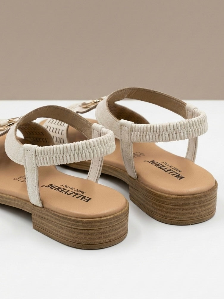 Sandali bassi Valleverde color bianco panna, fascia anteriore con lavorazione traforata geometrica opaca, dettaglio metallico dorato e cinturino elastico-retro.