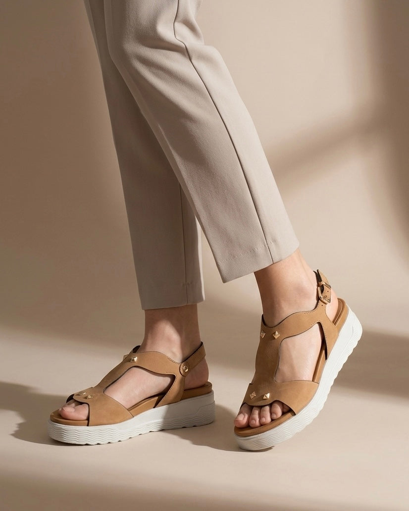 Sandali Stonefly da donna in vera pelle scamosciata color sabbia/beige, decorati con borchie dorate a piramide e dotati di suola platform bianca ammortizzata-indossati.