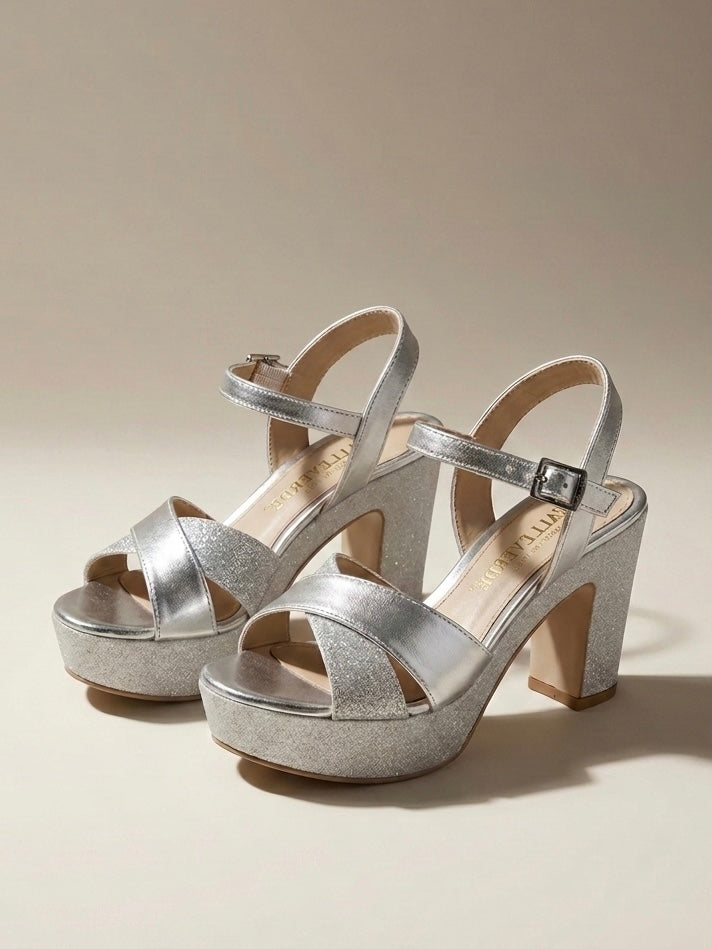 Sandali da donna marca Valleverde color argento (silver), con fasce incrociate in pelle laminata e glitter, tacco largo alto e plateau rivestito di brillantini.