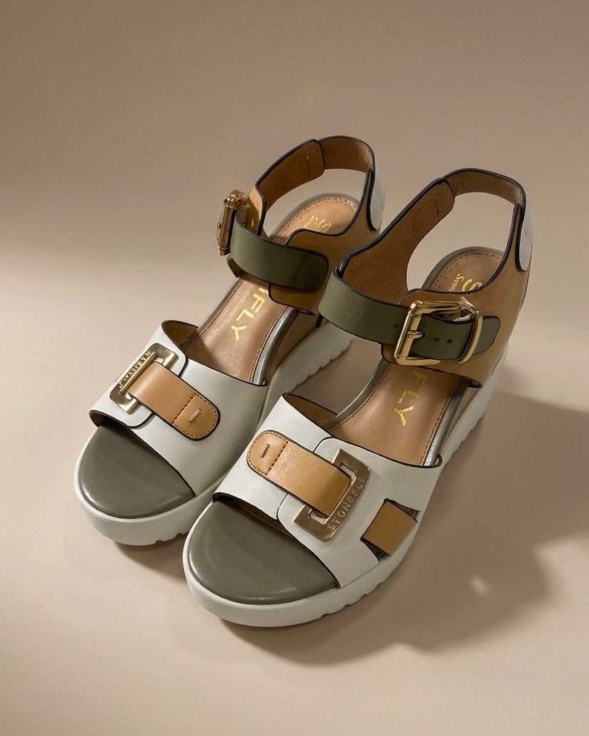 Sandali donna Stonefly con zeppa platform bianca, fasce in pelle bianca, cuoio e fango con grandi fibbie dorate logate.
