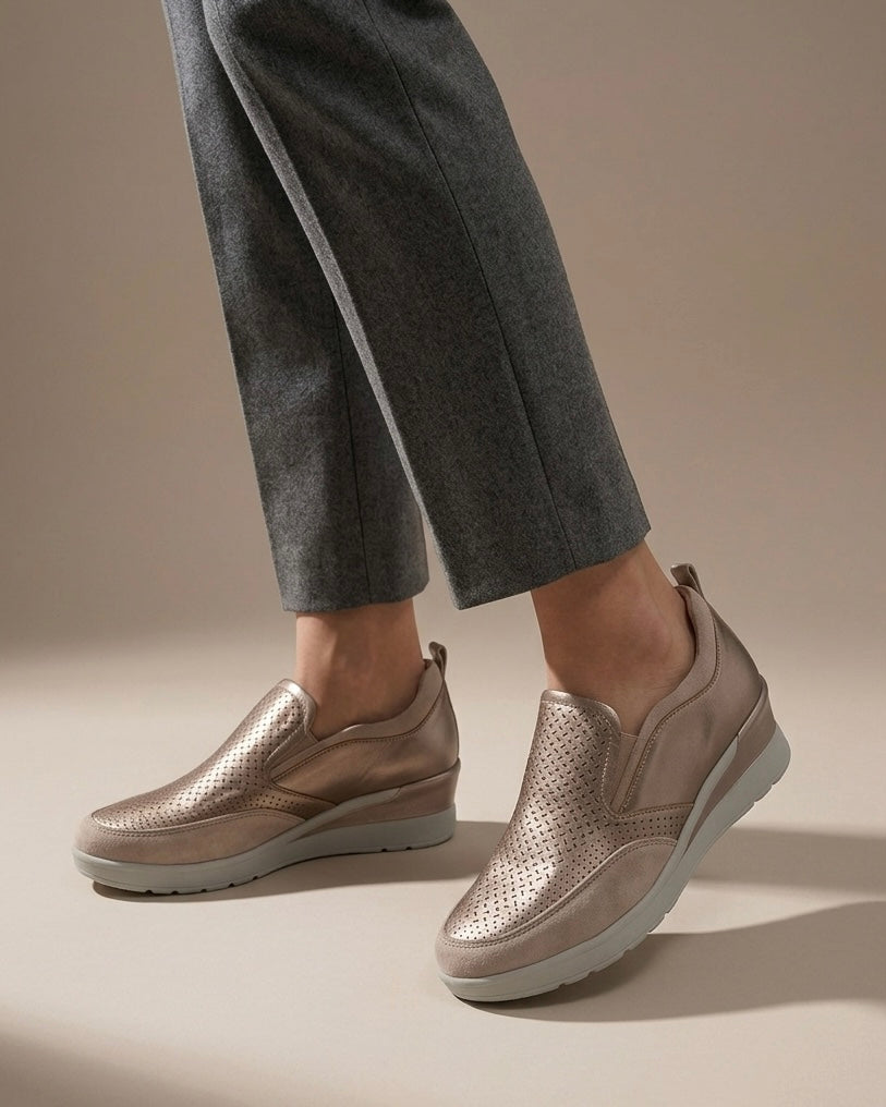 Scarpe slip-on donna Stonefly color bronzo metallizzato con tomaia traforata a laser, inserti elastici laterali e suola platform chiara-indossati.