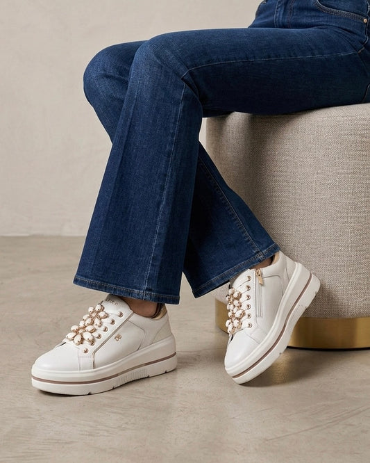 Sneakers platform Donna Serena in pelle bianca con finiture oro e pietre gioiello floreali sui lacci - indossato su modella.