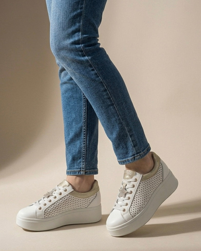 Sneakers da donna Igi&Co in pelle bianca con inserti laminati platino sul tallone e sulla linguetta, suola platform bianca scanalata e lacci bianchi-indossate.