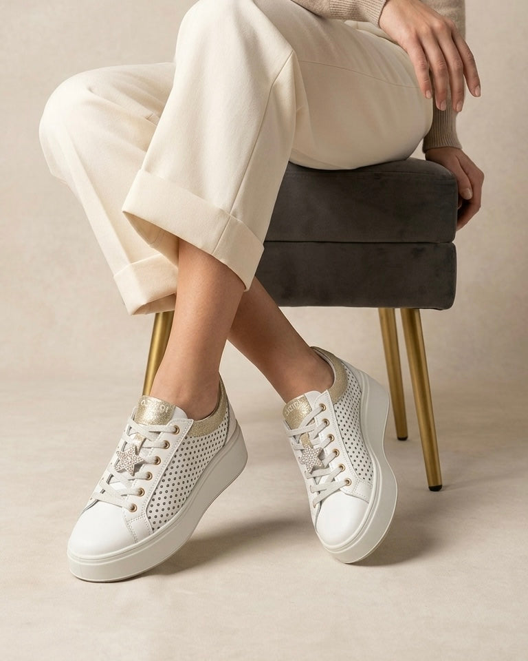 Sneakers da donna Igi&Co in pelle bianca con inserti laminati platino sul tallone e sulla linguetta, suola platform bianca scanalata e lacci bianchi-modella.