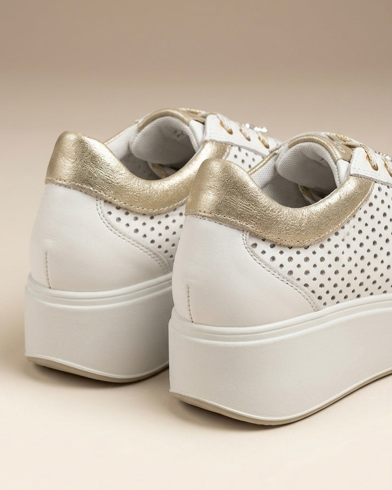 Sneakers da donna Igi&Co in pelle bianca con inserti laminati platino sul tallone e sulla linguetta, suola platform bianca scanalata e lacci bianchi-retro.