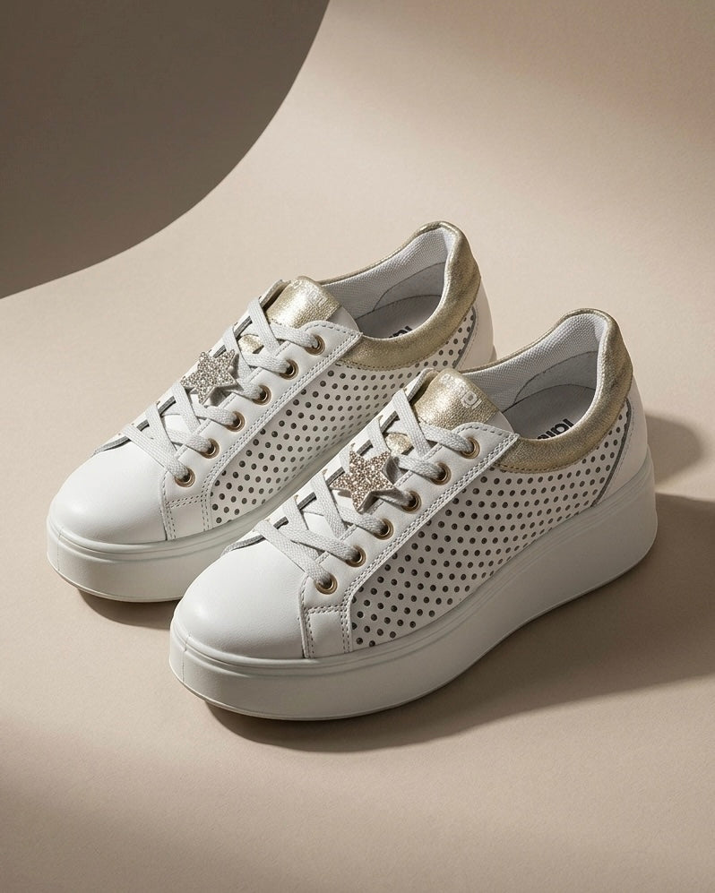 Sneakers da donna Igi&Co in pelle bianca con inserti laminati platino sul tallone e sulla linguetta, suola platform bianca scanalata e lacci bianchi.