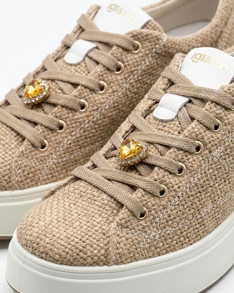 Sneakers da donna marca Igi&Co color beige panna con tomaia a texture intrecciata effetto rafia, cuori dorati metallizzati applicati sui lacci e suola platform bianca-dettaglio.