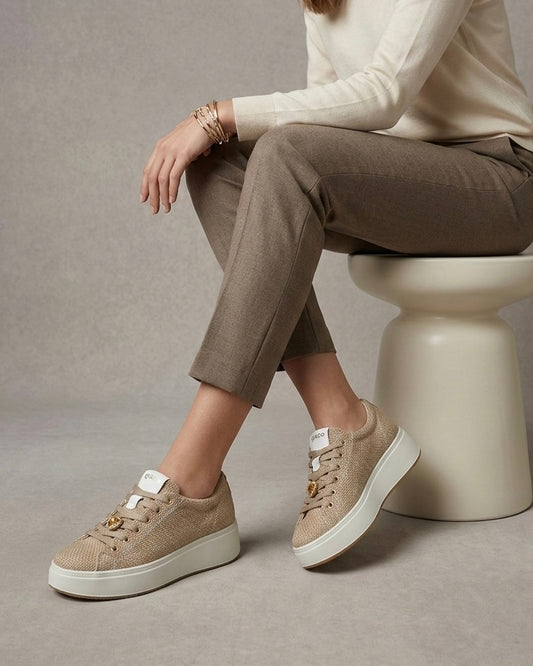 Sneakers da donna marca Igi&Co color beige panna con tomaia a texture intrecciata effetto rafia, cuori dorati metallizzati applicati sui lacci e suola platform bianca-modella.
