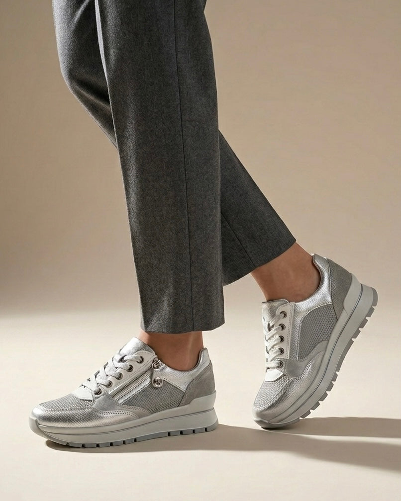 Sneakers da donna brand iMac color argento metallizzato, suola platform bianca, inserti in mesh e pratica zip laterale per una calzata facilitata-indossate.